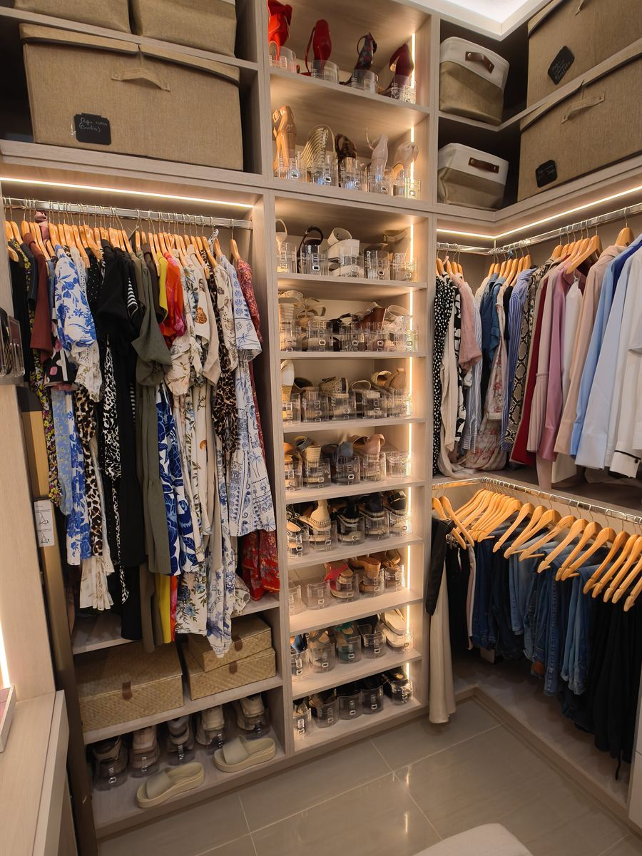 Walk-in closet with an LED-lit shoe display, double hanging and storage baskets on the top shelves